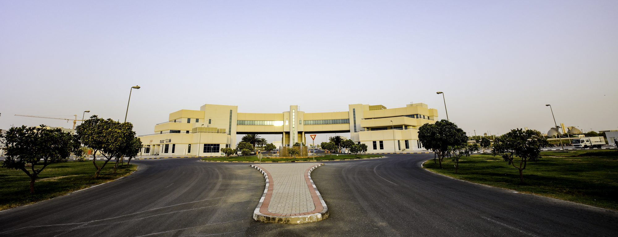 The Dubai Textile City administration building at dusk, seen from the approach road