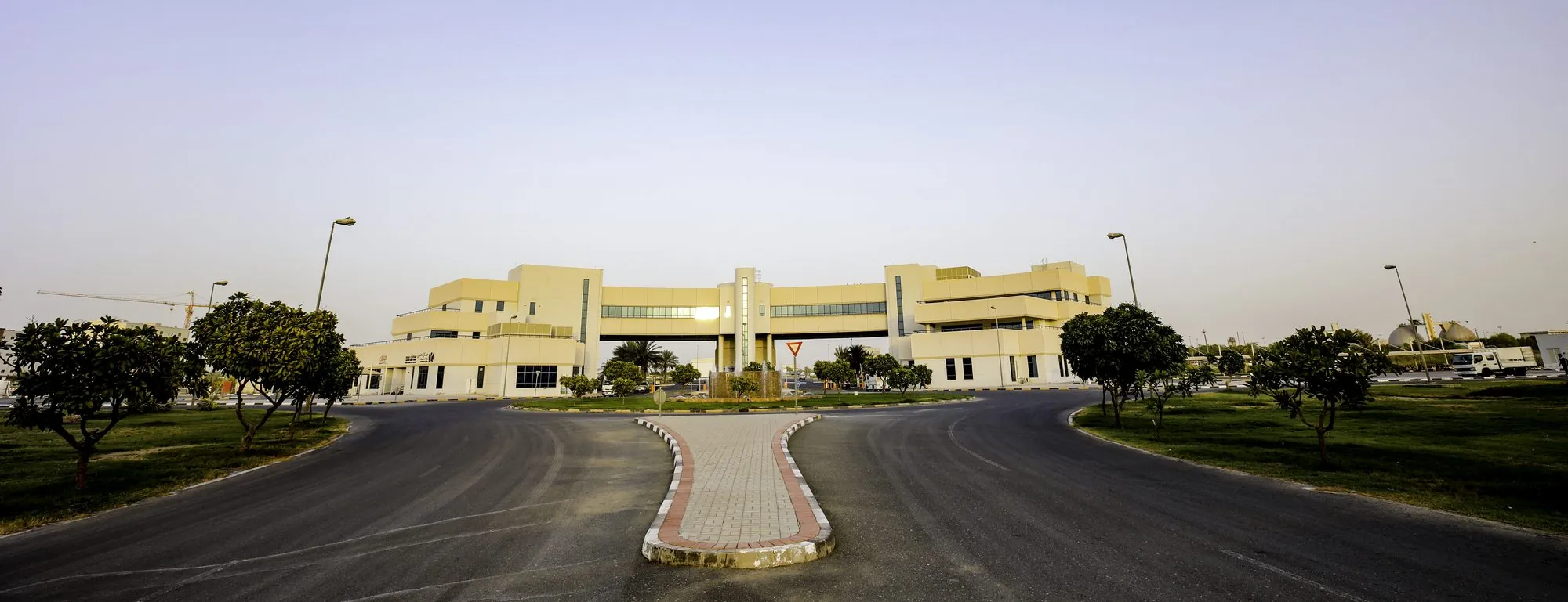 The Dubai Textile City administration building at dusk, seen from the approach road